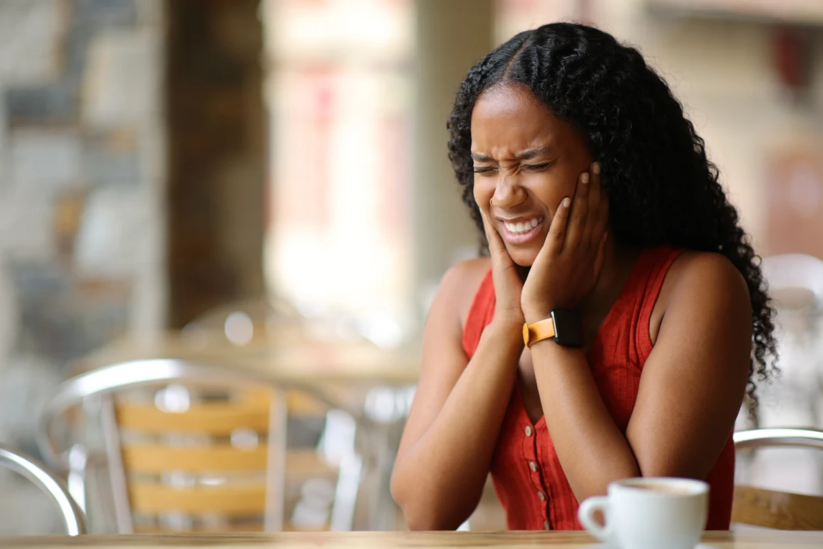 Woman holding her cheeks in dental pain